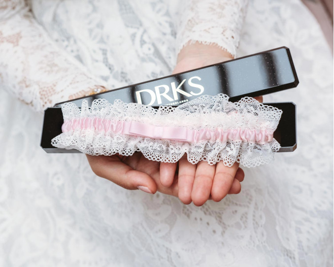 Roze kousenband bruid | Bruiloft DRKS.nl