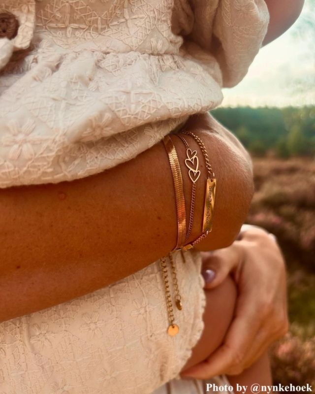 arm met drie gouden armbandjes om