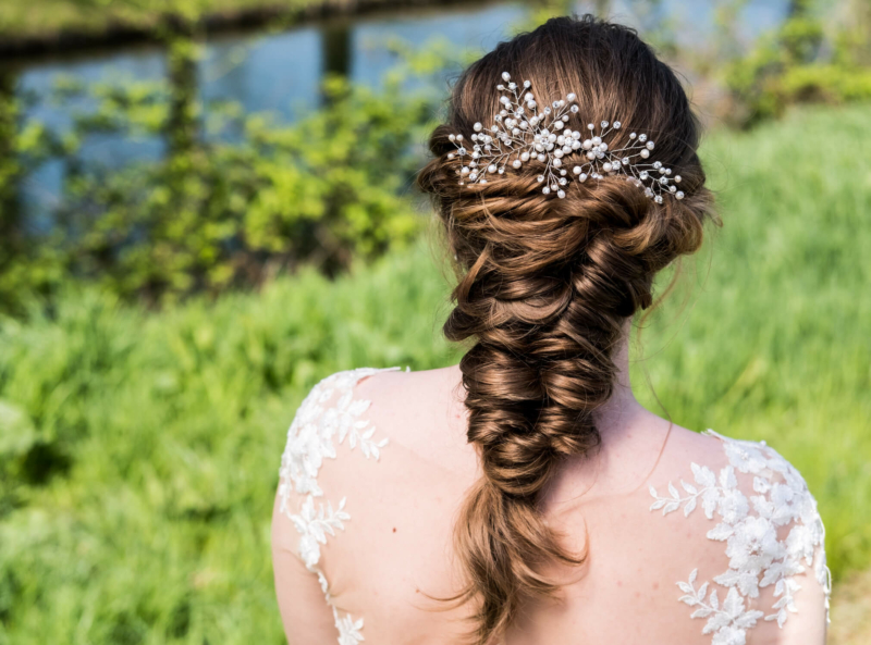 Bruid met vlecht en Haaraccessoire van DRKS met parels en kristal