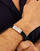 Man draagt dubbele leren armband met gravering