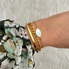 Vrouw draagt armbanden mix met sea shell bedel