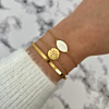 Gouden sea shell armband gecombineerd met initial armband en bangle