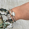 Mix van bangle en sea shell armband om pols