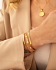 Model draagt gouden armparty