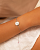 Vrouw met zilverkleurige birthstone armband met gravering 