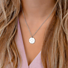 4 letter ketting om de hals bij een vrouw met blonde haren