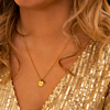 Model draagt gouden graveerbare ketting met birthstone steentje