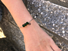 Armbandje met groene steentjes om arm