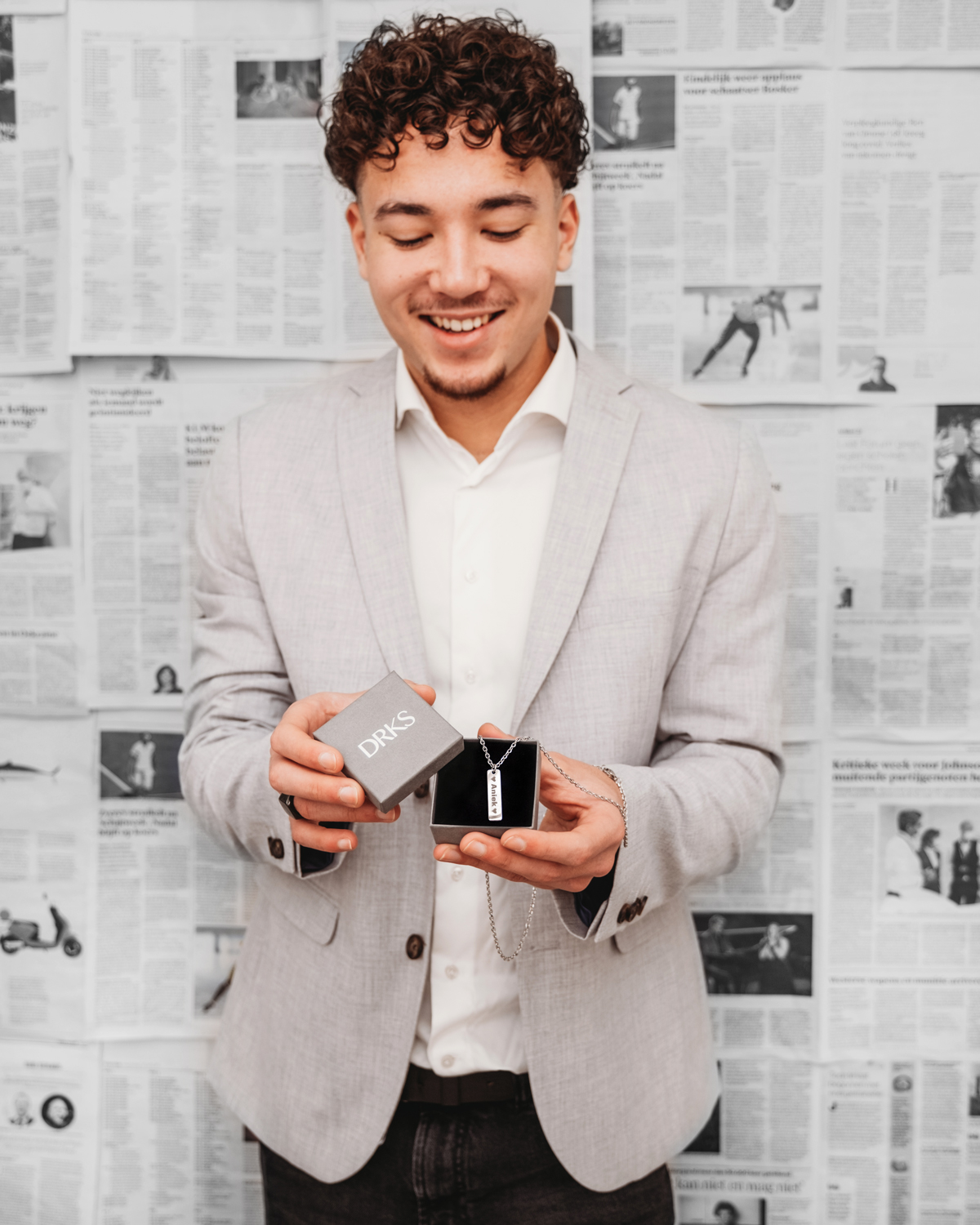 Heren ketting als cadeau met model en kranten op de achtergrond