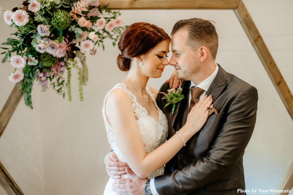 bruidspaar met zilveren bruidssieraden en bloemen