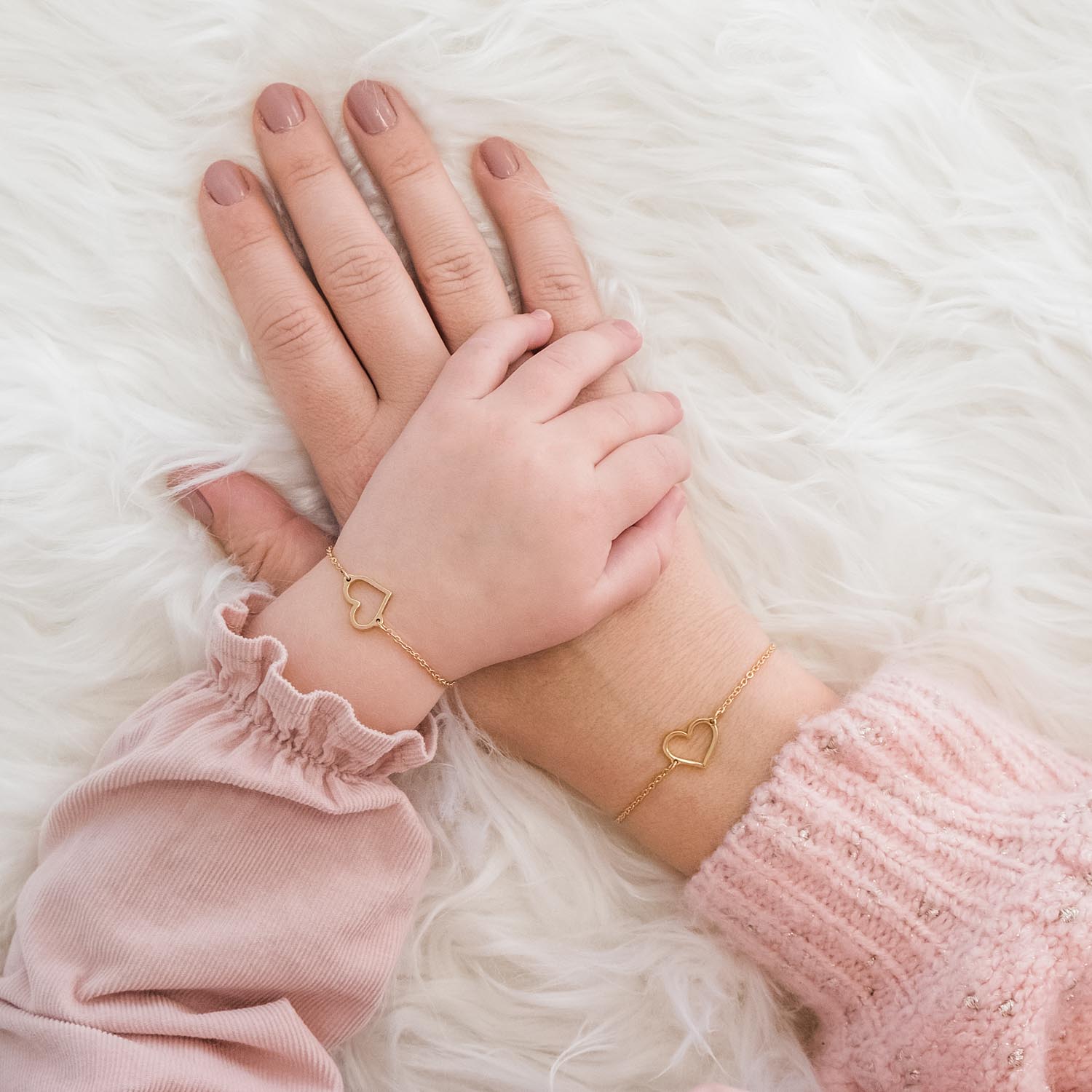 moeder en dochter dragen gouden armbandjes met hartje