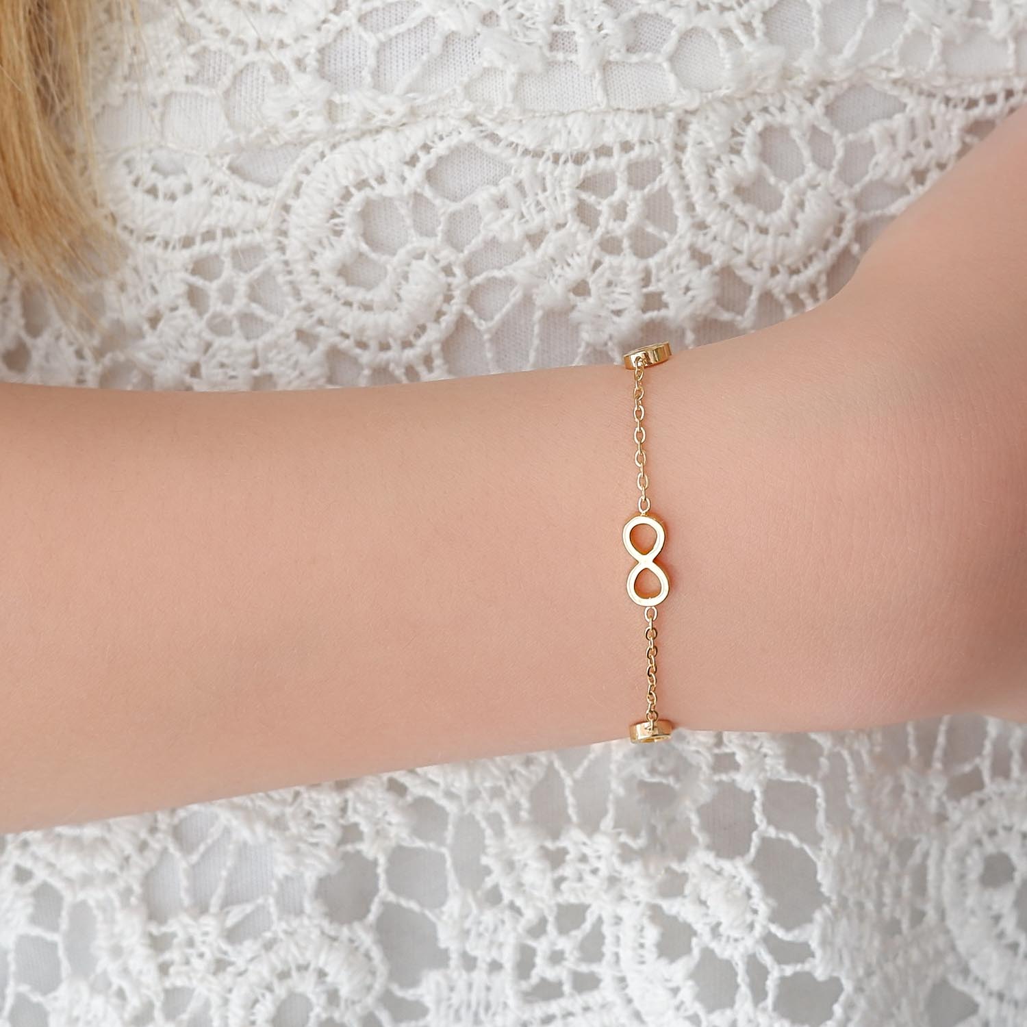 meisje draagt gouden armbandje met infinity tekens