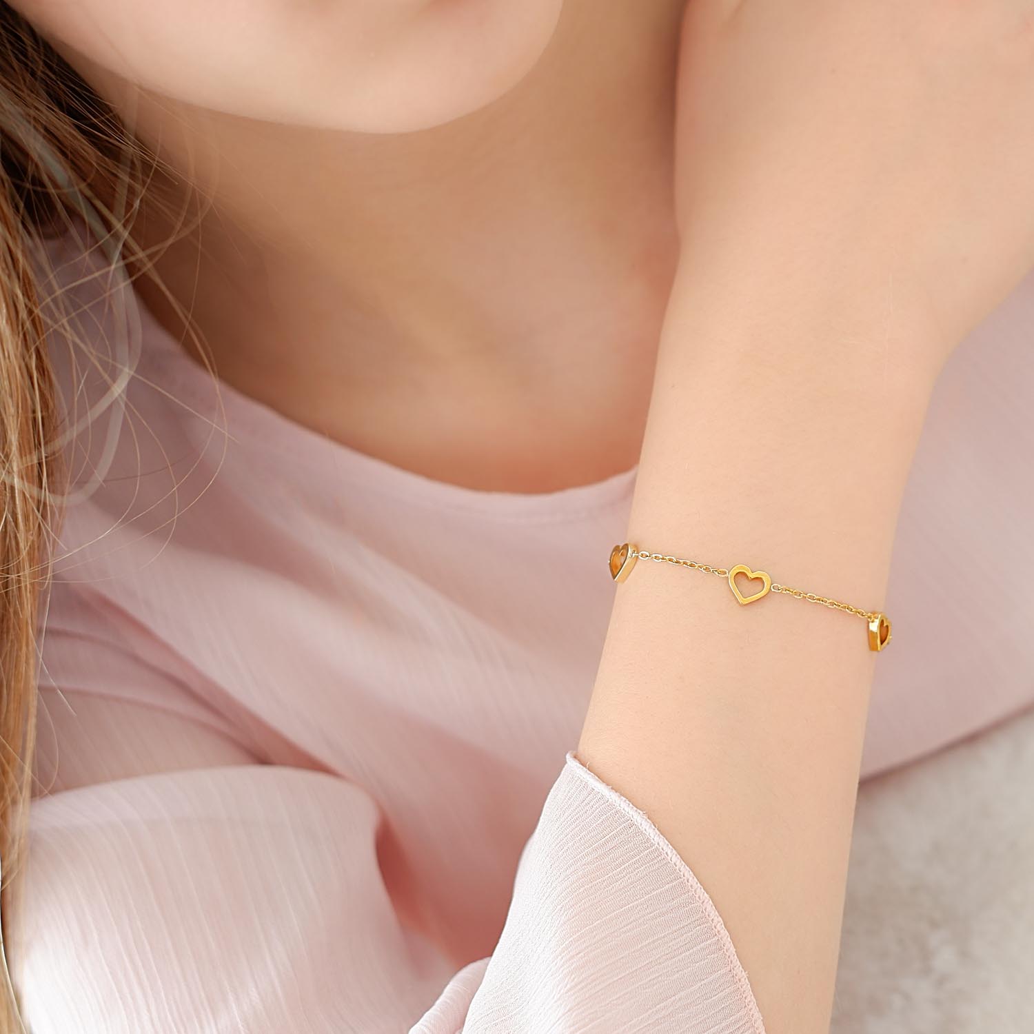 meisje draagt gouden armbandje met hartjes